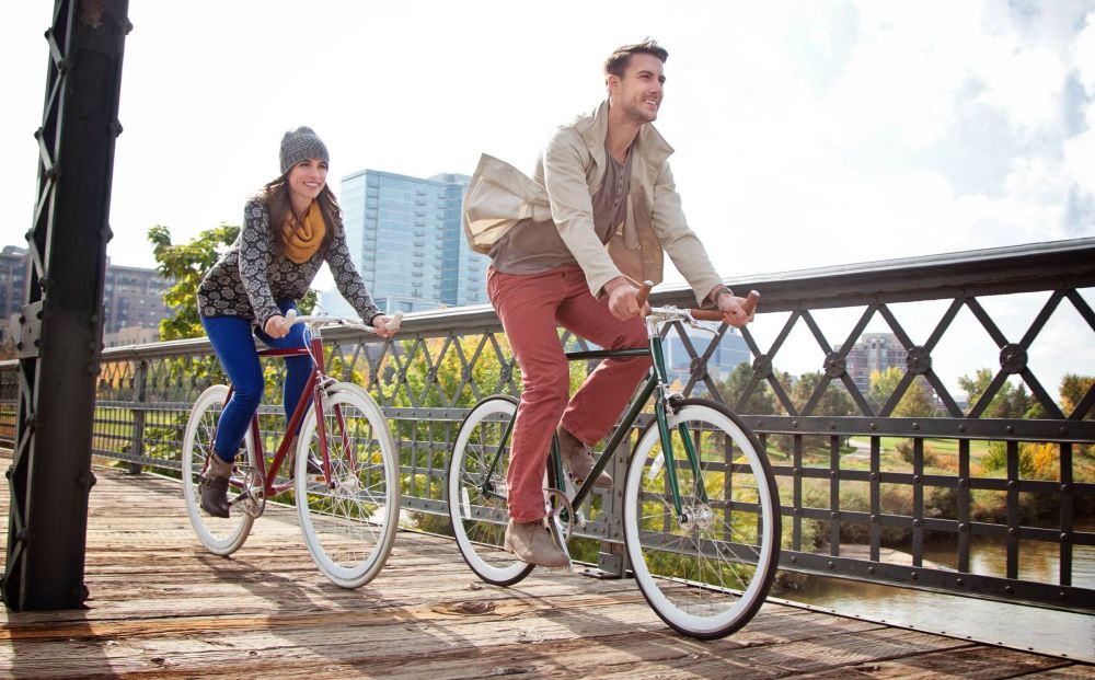 Alta Cosner luxury apartments in Fredericksburg, VA with a couple riding bikes in the neighborhood over a bridge