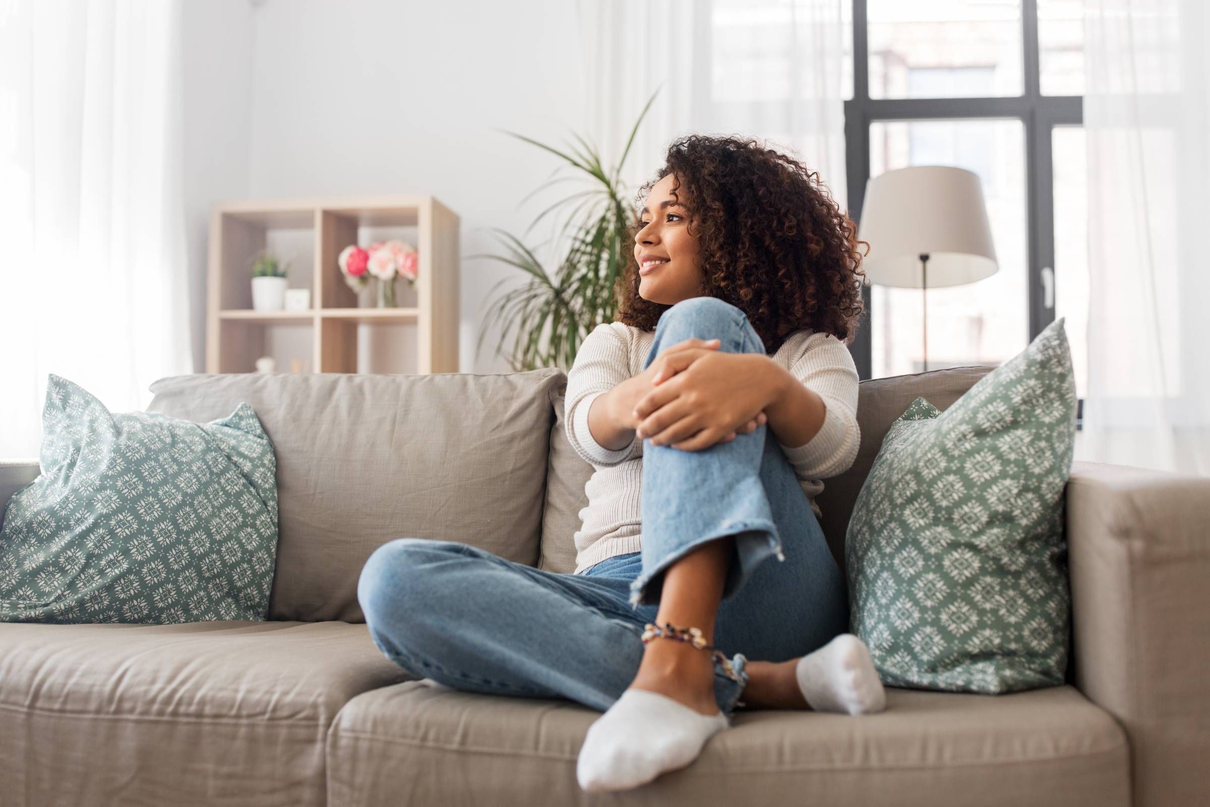 Alta Cosner Luxury Apartments happy young woman sitting on the couch at home