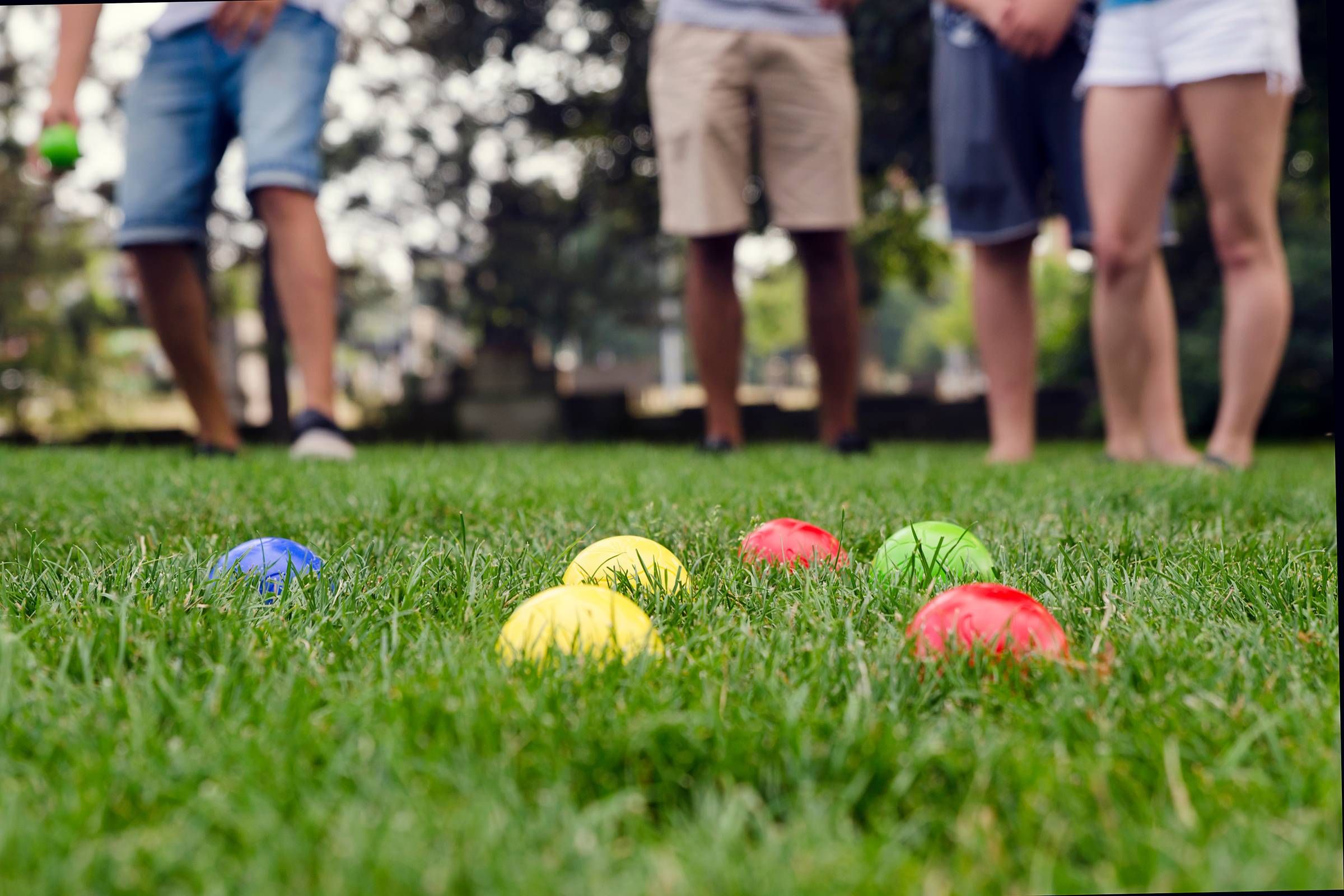 Alta Cosner Luxury Apartments with people playing bocce in the grass